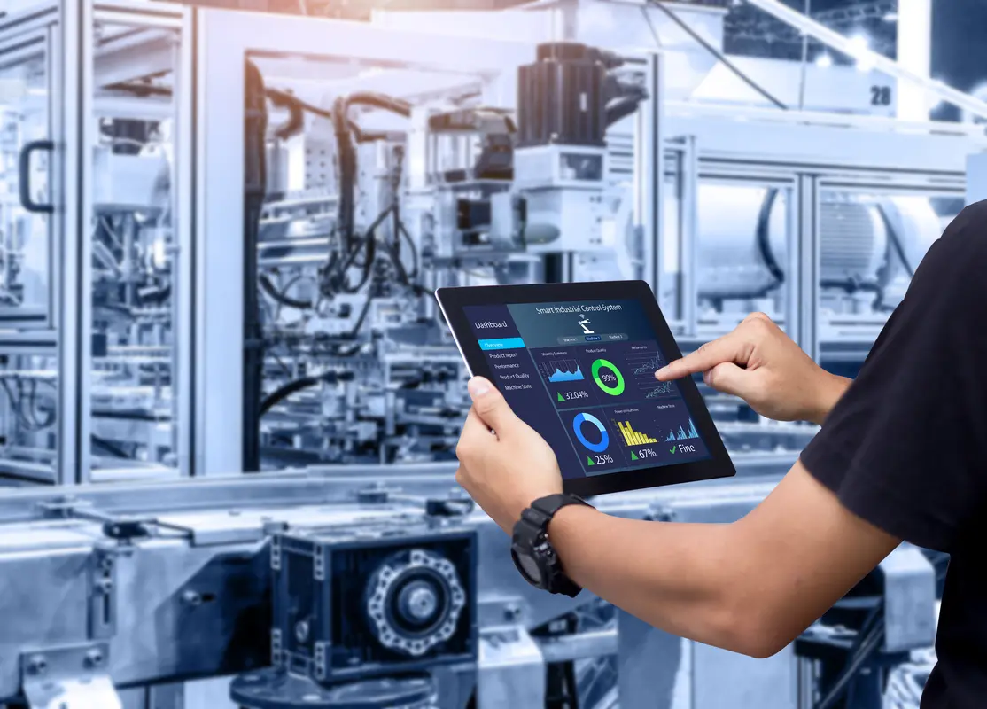 Técnico consultando en una tableta los datos de una línea de producción automatizada